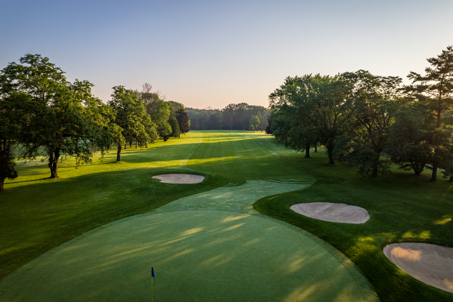 Aerial view of a Brown County Golf Course fairway and green at sunrise