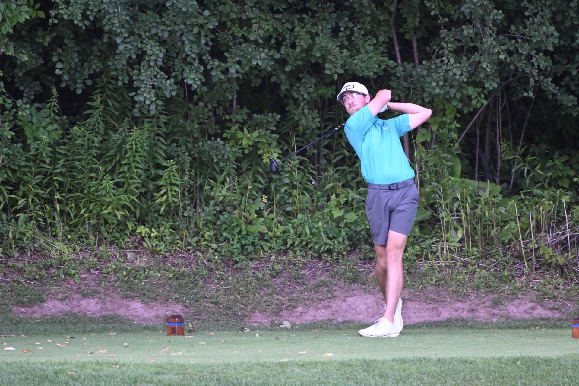 Nic Hughes swinging against a dense treeline at Brown County Golf Course